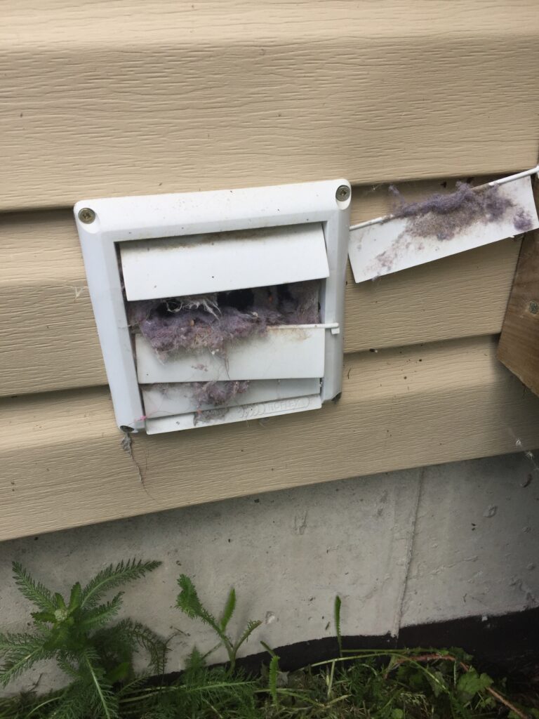 A technician removing dangerous lint buildup from a dryer vent at a residence in Warren, Ontario.