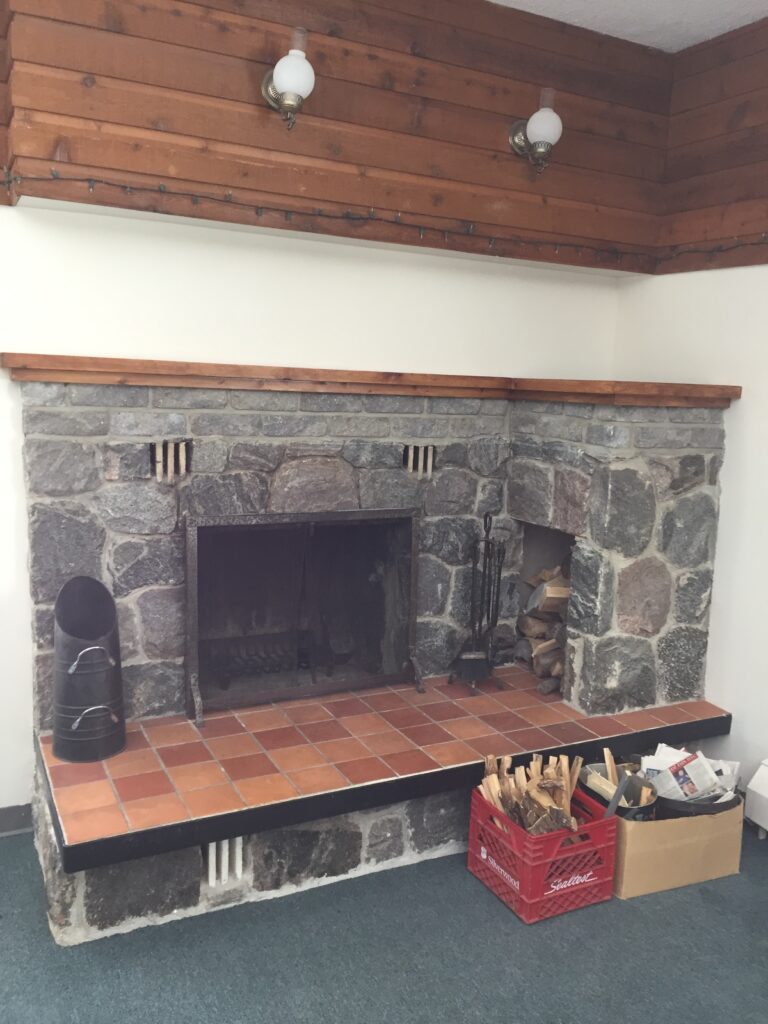 A professional chimney sweep performing a WETT-certified safety inspection on a wood stove in a Verner, Ontario farmhouse.